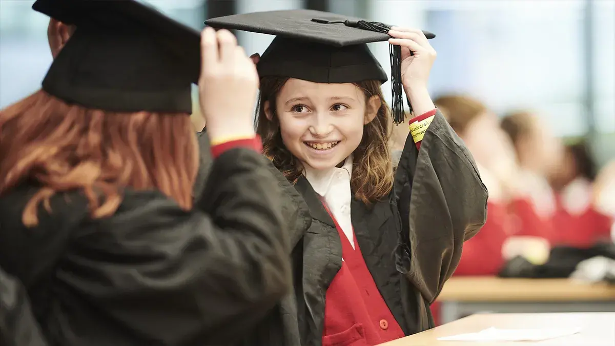Into University student and teacher in classroom in graduation outfits