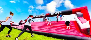 Participants running up an inflatable ramp
